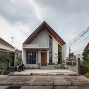 Rumah minimalis modern dengan atap pelana, fasad beton ekspos, dan pintu kayu.
